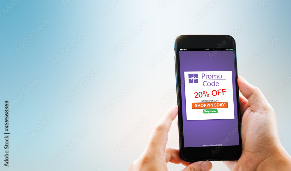 Online Discount coupon promotion code concept.Hands holding mobile phone Online Discount coupon promotion code concept.Hands holding mobile phone
