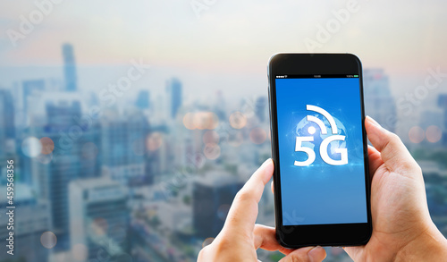 5G high speed new generation networks connection concept.Man hands holding mobile phone on blurred city as background