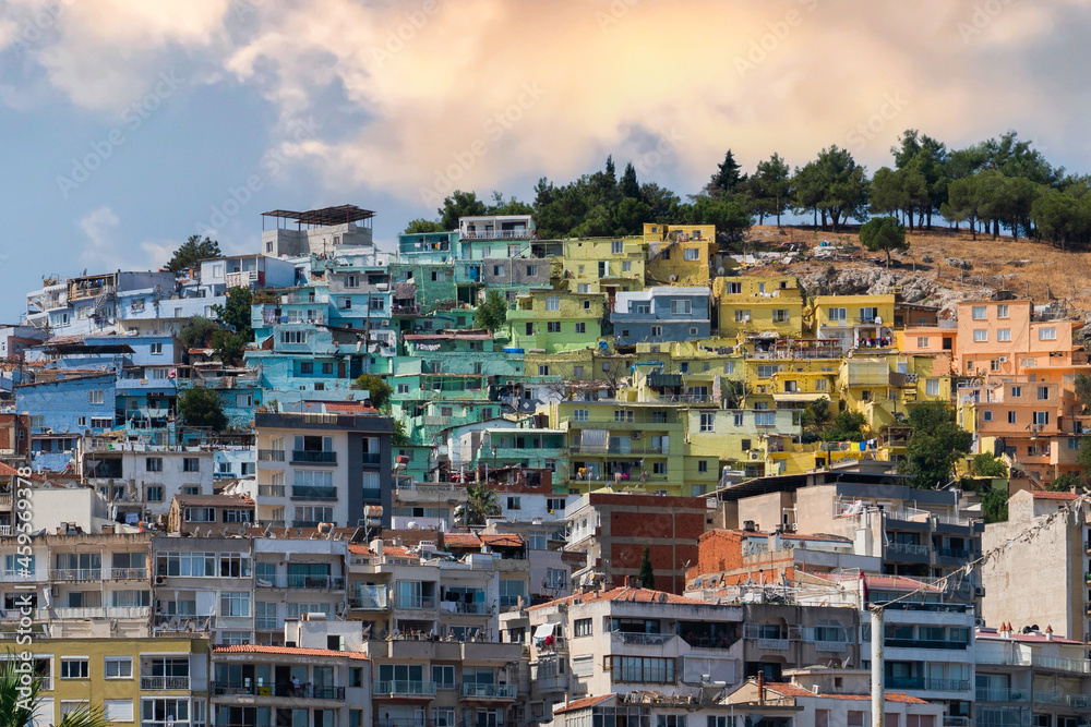 Colorful Kusadasi houses on the hill seen through palm leaves, , Aydin, Turkey