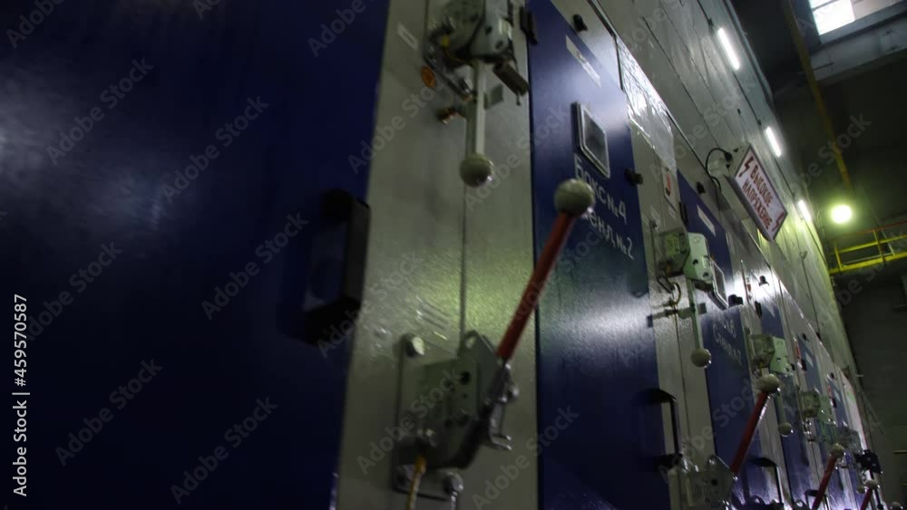 Motion past closed white and blue cabinets with levers in control room of production plant close low angle shot Motion past closed white and blue cabinets with levers in control room of production plant close low angle shot