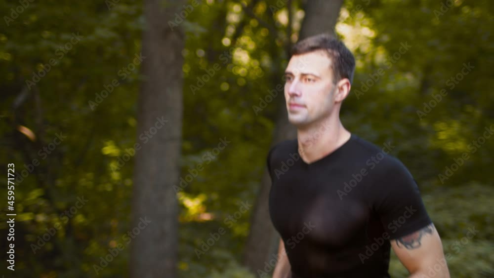 Active and healthy lifestyle concept. Close up portrait of motivated sporty man running in morning public park