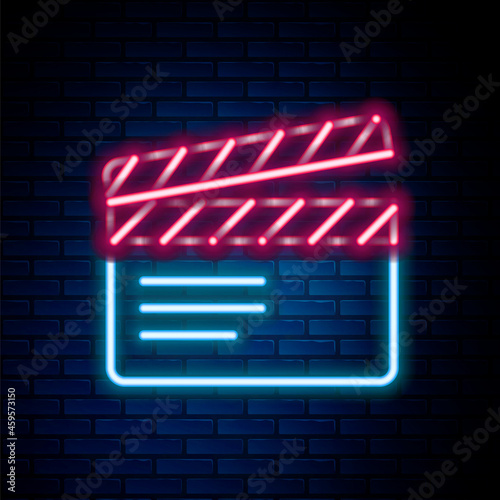 Glowing neon line Movie clapper icon isolated on brick wall background. Film clapper board. Clapperboard sign. Cinema production or media industry. Colorful outline concept. Vector