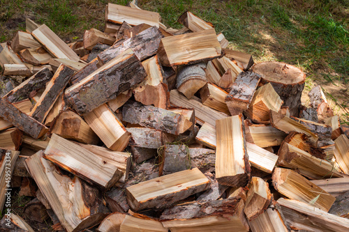 Chopped wood in a heap outside, prepared for the winter to heat the house. Fuel for stove and fireplace