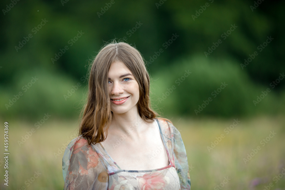 sweet brunette with blue eyes smiles widely in the field