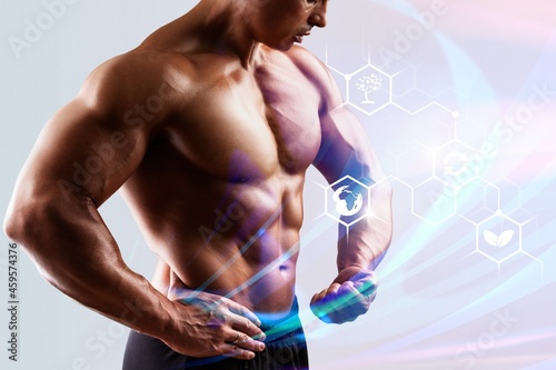 Muscular male torso and testosterone formula against background. photo