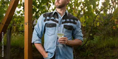 cropped vinedresser man hold wineglass at vineyard outdoor, grape farm photo