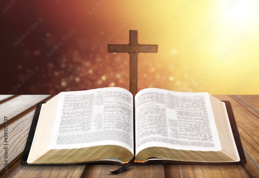 Holy Bible with wooden cross on the bokeh background Holy Bible with wooden cross on the bokeh background