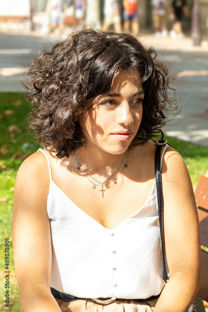 portrait of a young Caucasian woman with curly hair and thoughtful gesture portrait of a young Caucasian woman with curly hair and thoughtful gesture