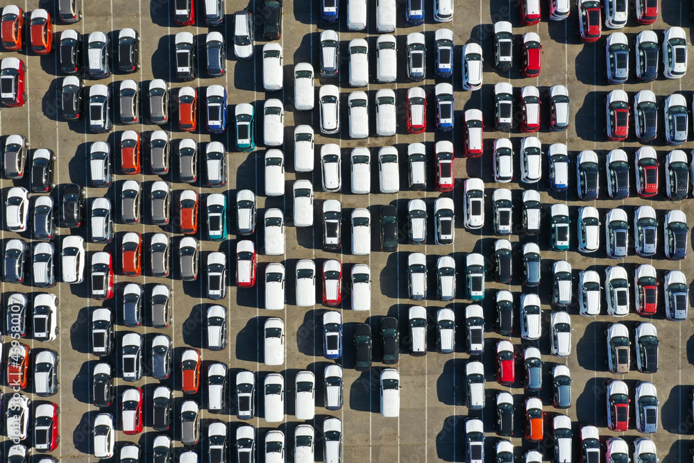 Obraz premium Aerial view from drone to automobile customs terminal. Large number of cars at customs terminal are awaiting shipment. Accumulative customs platform for cars.