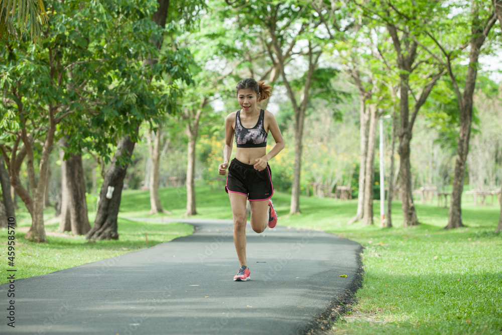 Asian woman warming up before running in the park Asian woman warming up before running in the park