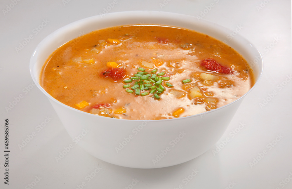 Sopa de abóbora e tomate seco na tigela em fundo branco para recorte.