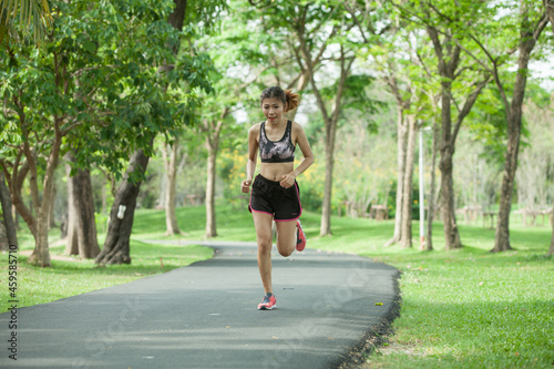 Asian woman warming up before running in the park