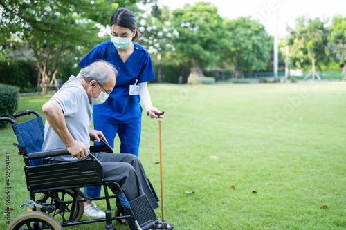 Asian young woman nurse at nursing home take care senior man on walker