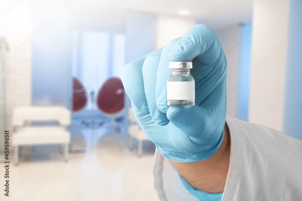 Mockup blank label of medical vaccine vial in doctor's hand, glass bottle for injection. Mockup blank label of medical vaccine vial in doctor's hand, glass bottle for injection.