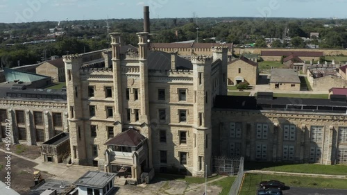 Aerial view of the derelict and abandoned Joliet prison or jail, a historic place. Drone rotating left to right around front gate tower of Joliet prison. photo