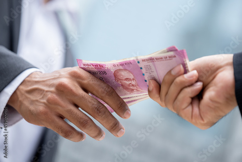 Obraz na plátne Businessman hand giving money Indian rupee currency to partner, loan and bribery