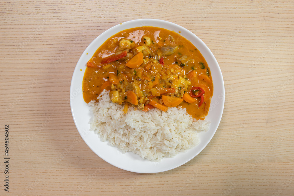 A plate of rice with chicken and vegetable curry. A plate of rice with chicken and vegetable curry.