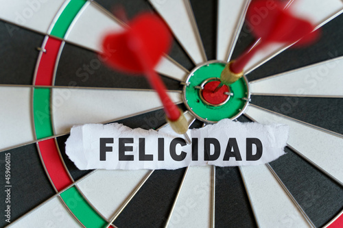 The picture shows a target, darts and a torn piece of paper with the inscription - FELICIDAD photo