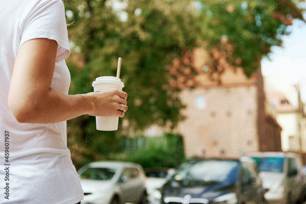 Coffee paper cup in woman hands. Woman drinks coffee to go at city street. Coffee paper cup in woman hands. Woman drinks coffee to go at city street.