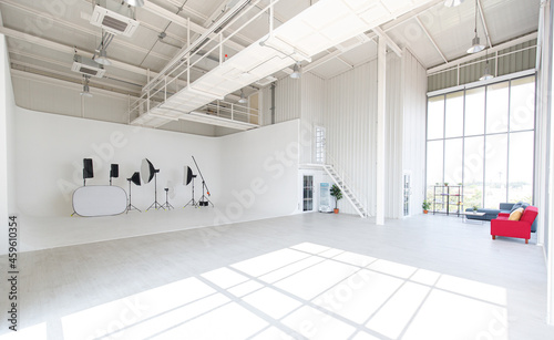 Empty white photo studio with lighting tools