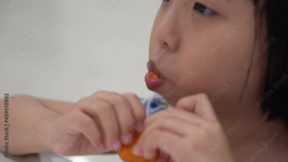 Close up the happy chinese girl eat nugget Close up the happy chinese girl eat nugget
