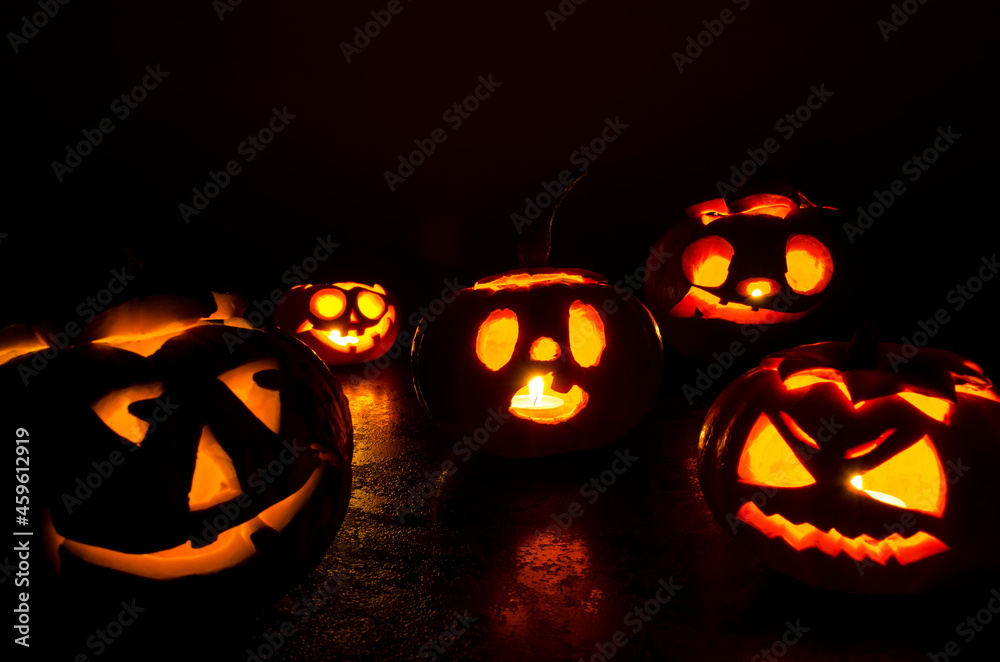 Halloween carved bright orange pumpkin jack lantern with different expressions of immotions on a dark textured background glow brightly in the dark Halloween carved bright orange pumpkin jack lantern with different expressions of immotions on a dark textured background glow brightly in the dark