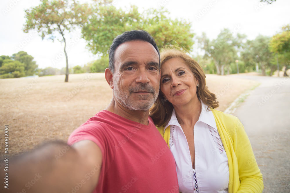 Selfie of happy senior couple outdoors in fall. Portrait of mature dates looking at camera and smiling. Mature love concept Selfie of happy senior couple outdoors in fall. Portrait of mature dates looking at camera and smiling. Mature love concept