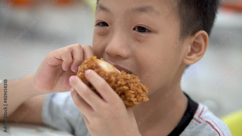 Little kid use hand eat fried chicken Little kid use hand eat fried chicken