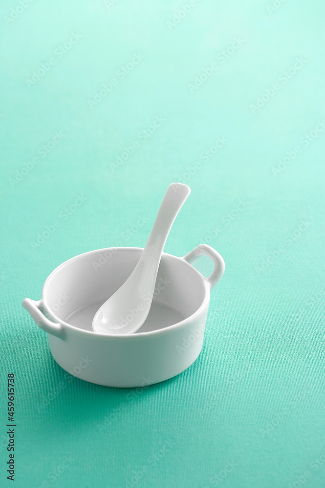 Ceramic spoon in cup on pastel background Ceramic spoon in cup on pastel background