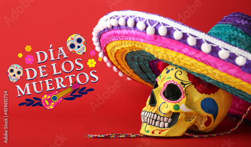 Painted human skull for Mexico's Day of the Dead (El Dia de Muertos) and sombrero hat on color background