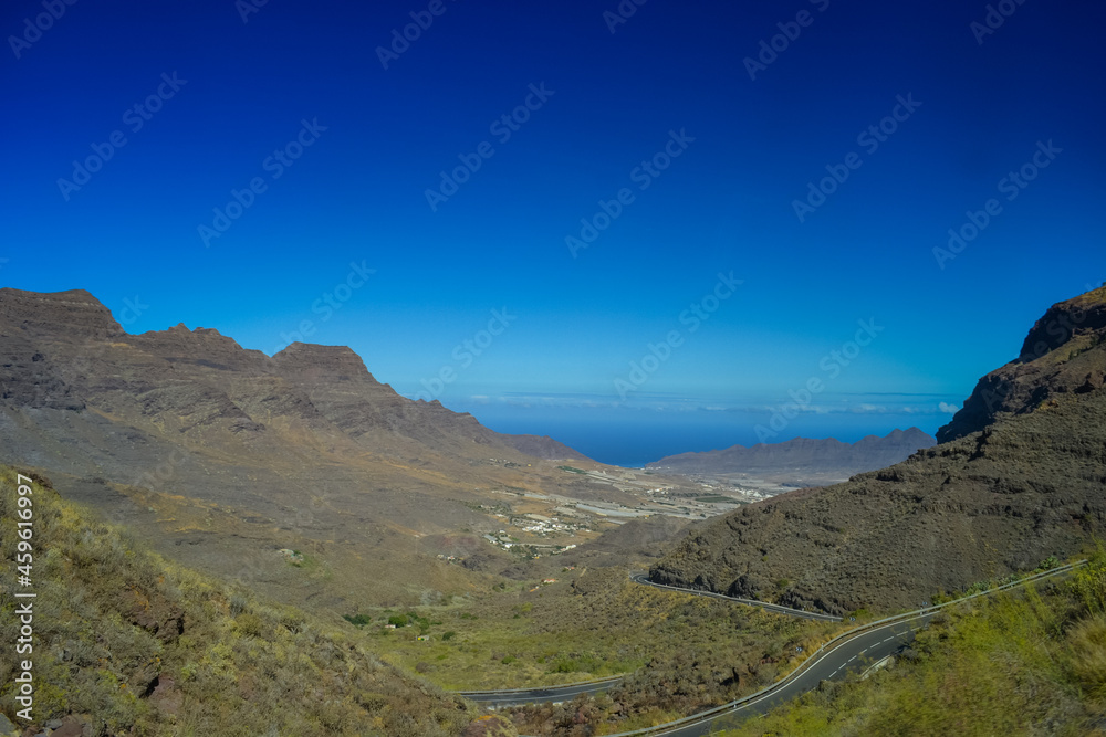 Rocks in the north of the Gran Canaria island. The road passes over the cliffs, the ocean is visible