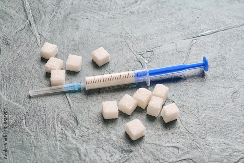 Syringe for insulin injection and sugar on grunge background