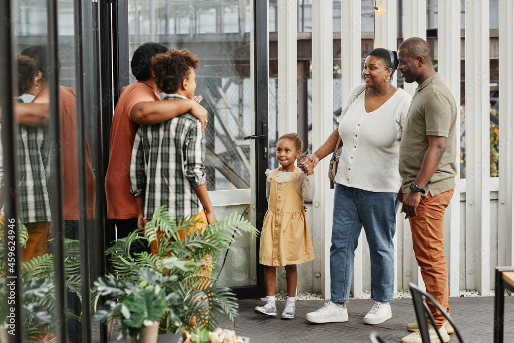 Full length portrait of happy multi-generational family chatting during gathering outdoors at terrace Full length portrait of happy multi-generational family chatting during gathering outdoors at terrace