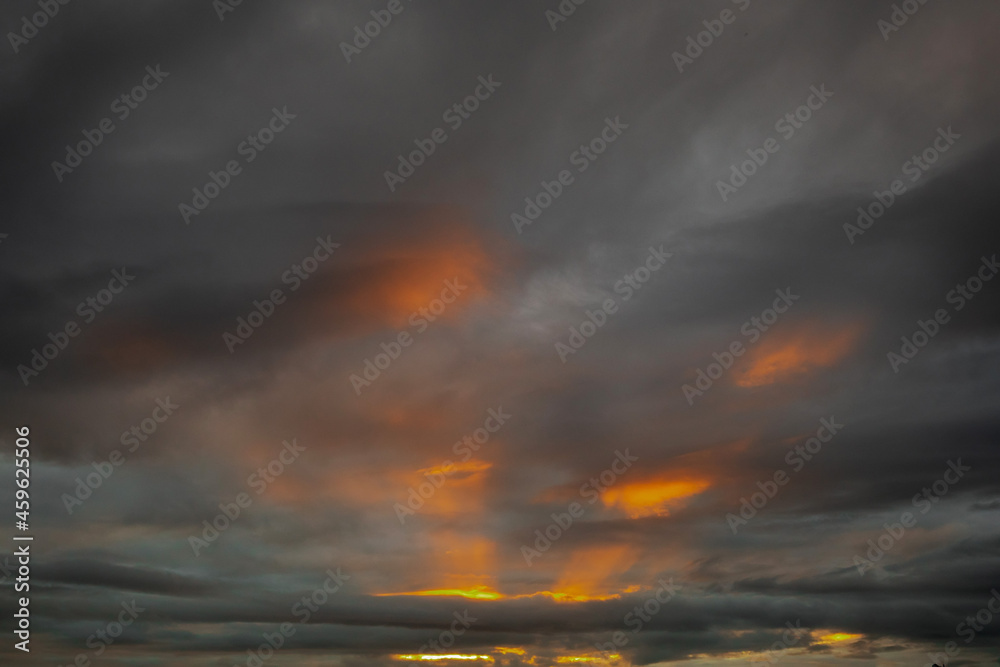 Obraz premium Dark sunrise sky with warm orange rays of light. Nature background