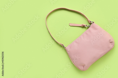 Stylish handbag on color background