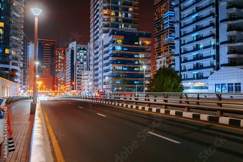 Empty asphalt road with modern buildings at night in Dubai © fotofabrika