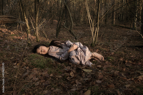classic portrait of child in dress sleeping in the woods in autumn or winter photo