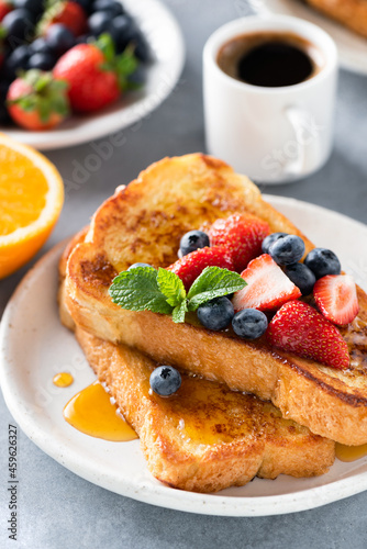 French toasts served with fresh berries, honey and cup of black coffee