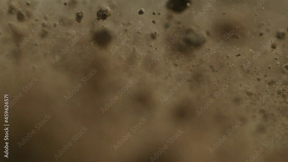 Flying dirt, soil, earth, particles and chunks seen in detail and in slow motion Flying dirt, soil, earth, particles and chunks seen in detail and in slow motion