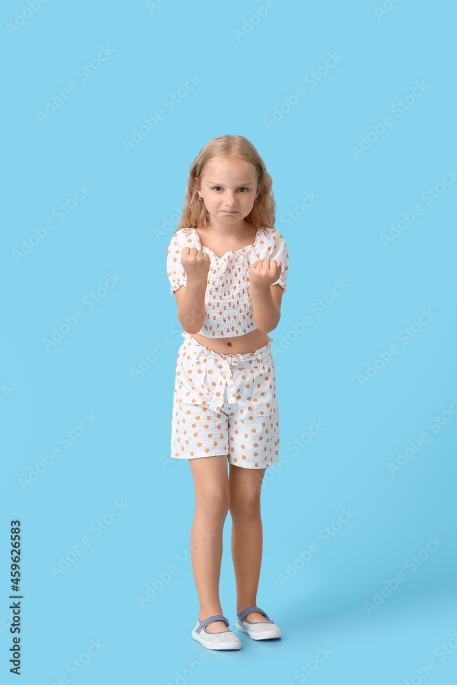 Angry little girl on color background