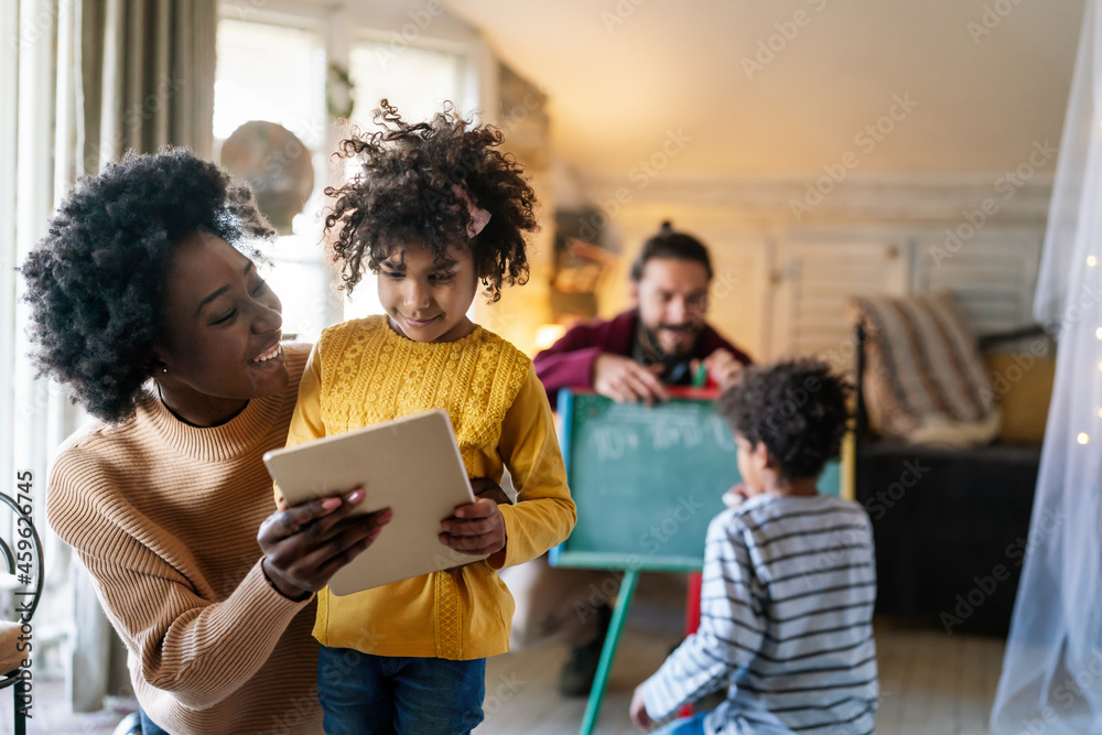 Fototapeta premium Happy family. Multiethnic parents are playing with children. Education technology people fun concept