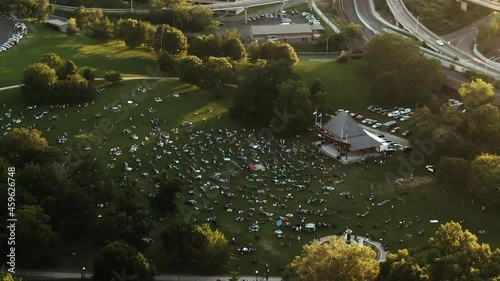 People sitting on grass field in Bushnell park enjoying show, Hartford photo