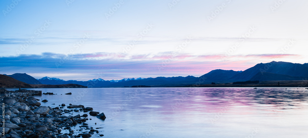 Panorama view of Lake Tekapo with the Southern Alps in the background at sunrise,  Mackenzie country, South Island.