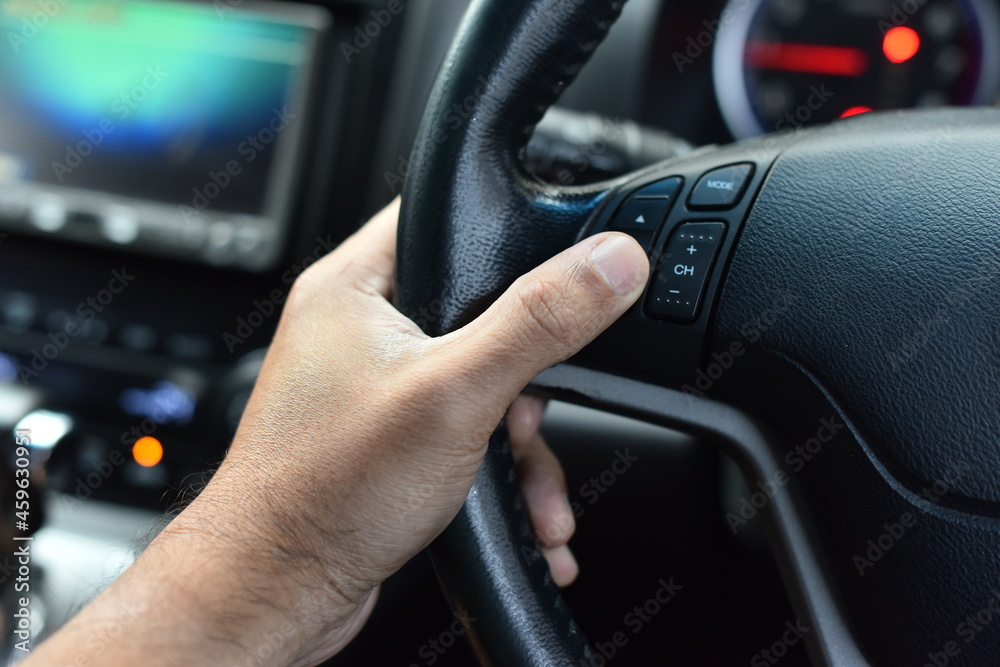 Car steering wheel in the hands of a man in a car
