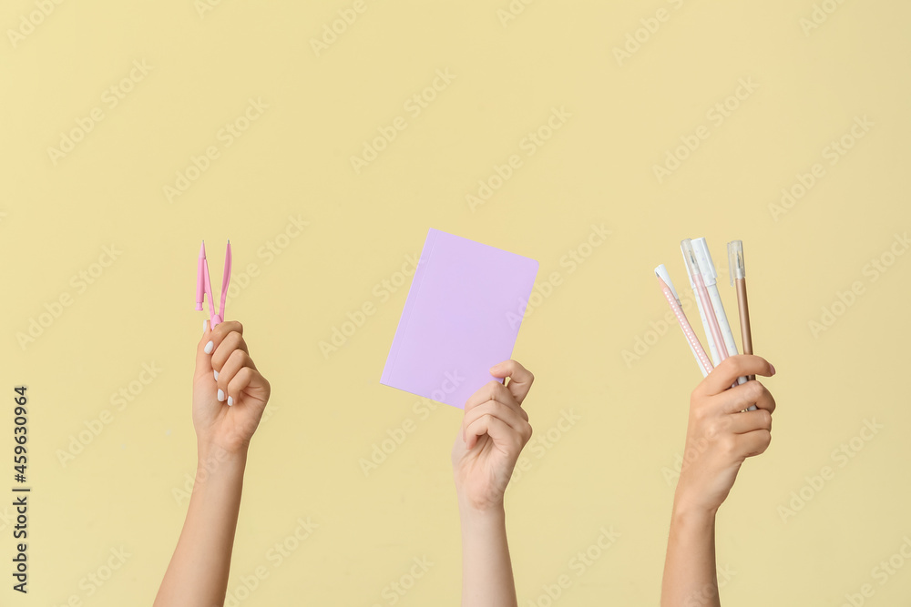 Female hands with school supplies on color background Female hands with school supplies on color background