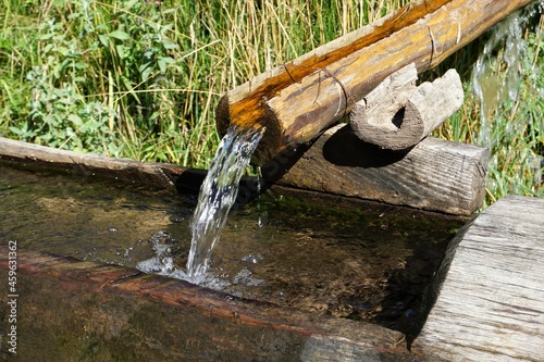 frisches Quellwasser fließt in Holztrog, Quelle, Wasser aus den Bergen