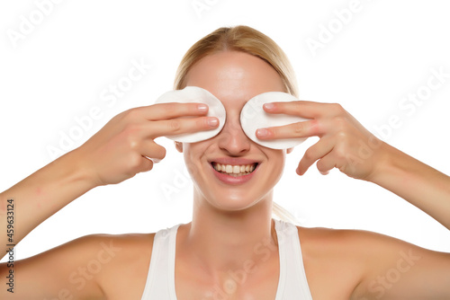 Obraz na plátně young happy blond woman with headband cleans her face with cotton pads