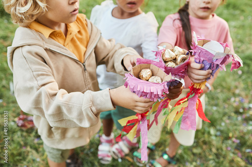 Close up children holding sweets from pinata during Birthday party outdoors, copy space