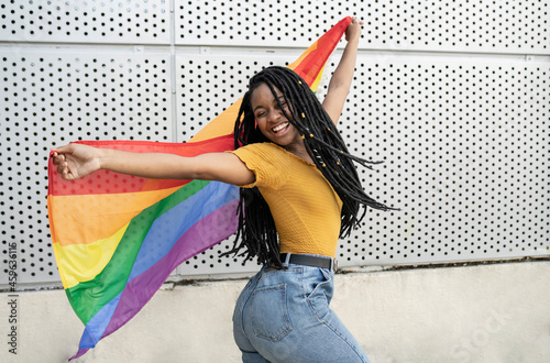 Carefree lesbian woman dancing with pride flag
