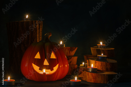 Halloween pumpkin head jack lantern with burning candles in the dark.